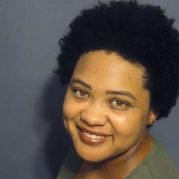 a woman with black hair smiling at the camera.