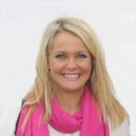 a woman wearing a pink scarf and smiling.