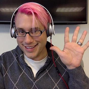 a man with pink hair wearing headphones and listening to music.