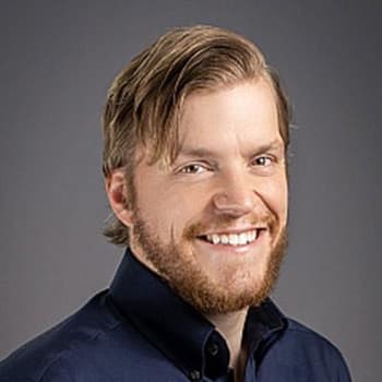 a man with a beard smiling at the camera.