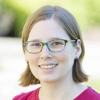 a woman with glasses is smiling for the camera.