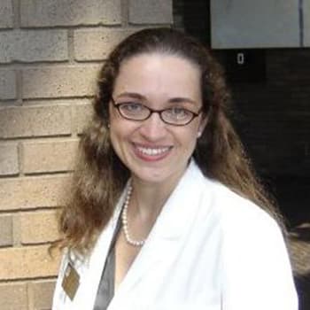 a woman wearing glasses and a white robe.
