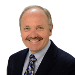 a man in a suit and tie smiling.