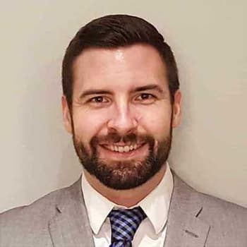 a man with a beard wearing a suit and tie.