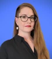 a woman wearing glasses and a black shirt.