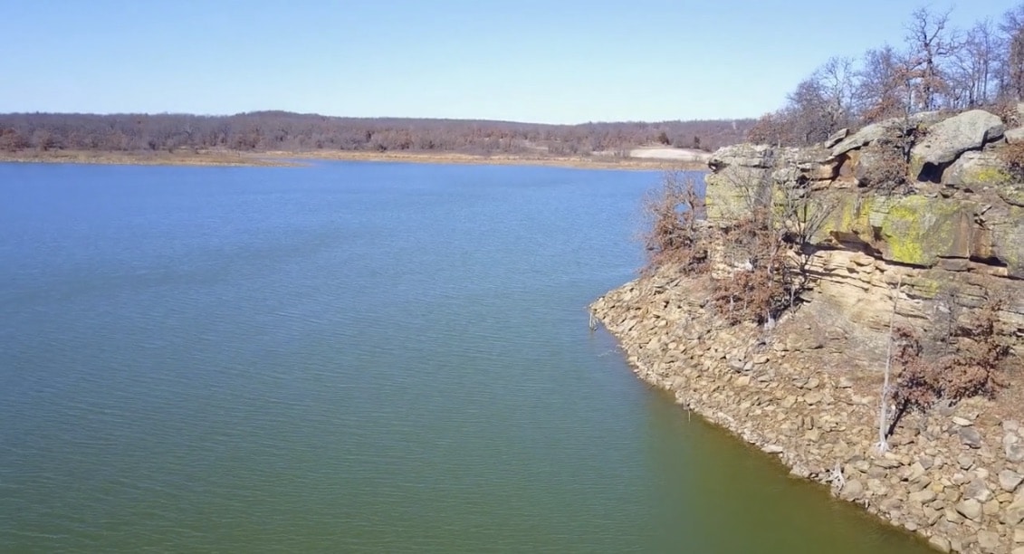 a large body of water surrounded by a rocky cliff.