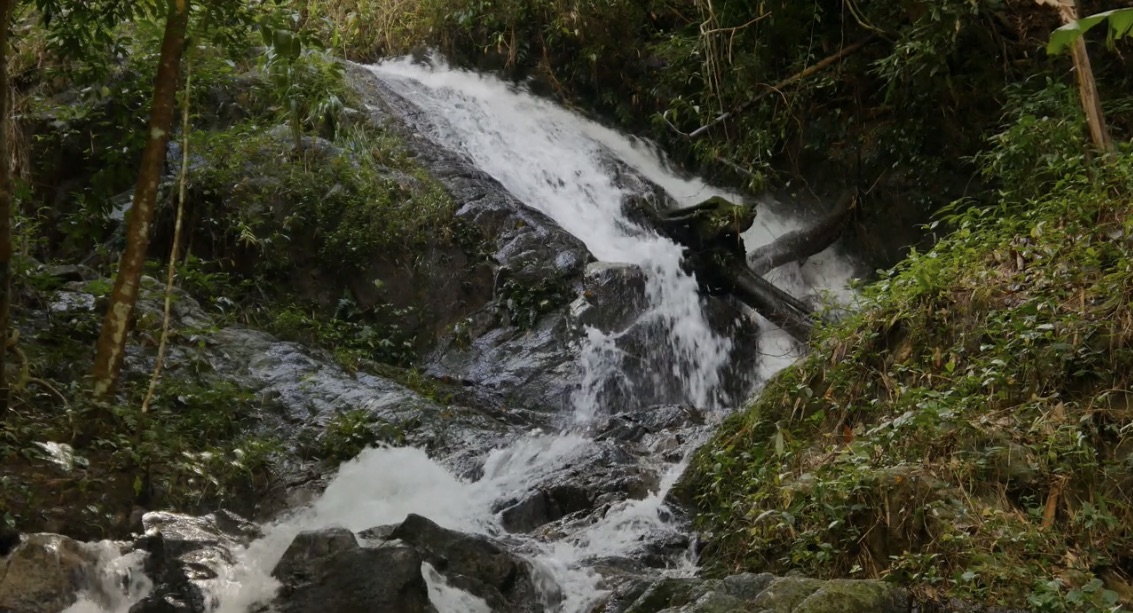 a man standing at the top of a waterfall.