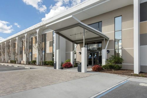 the front entrance of a hotel with a parking lot.