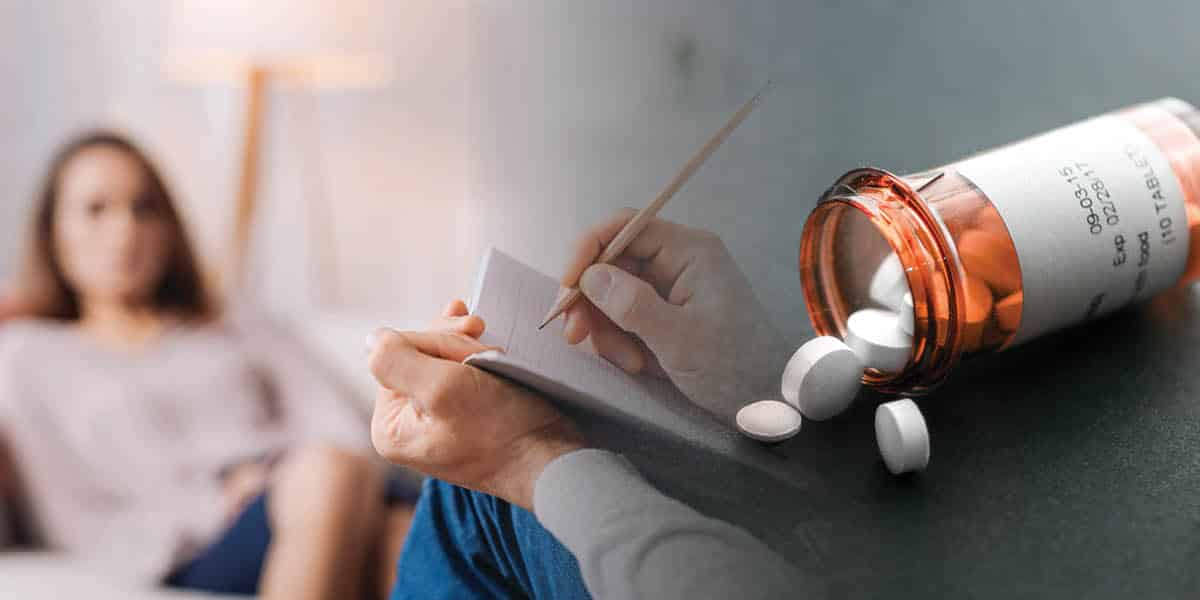 a woman sitting on a bed with a bottle of pills and a notepad.