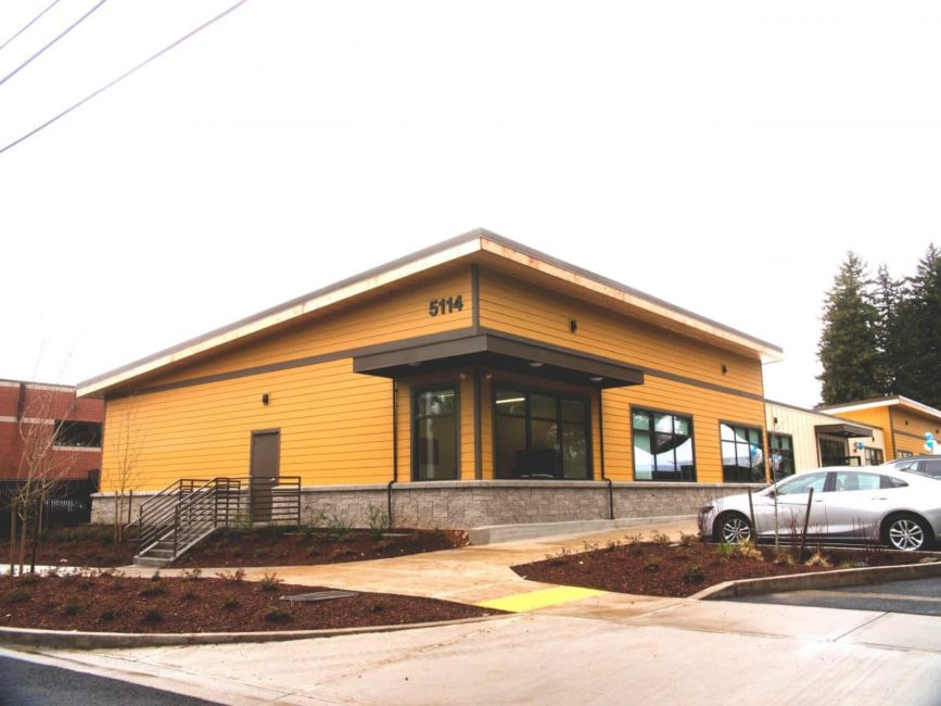 a yellow building with a car parked in front of it.