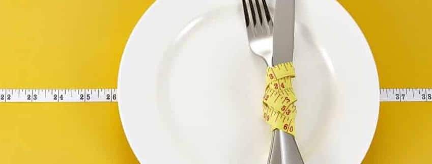a fork and knife wrapped in a tape measure.