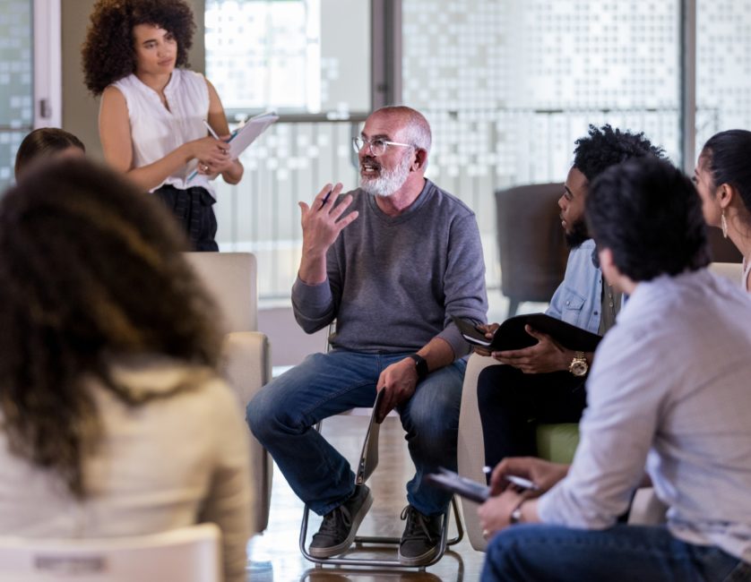 a group of people sitting around each other.