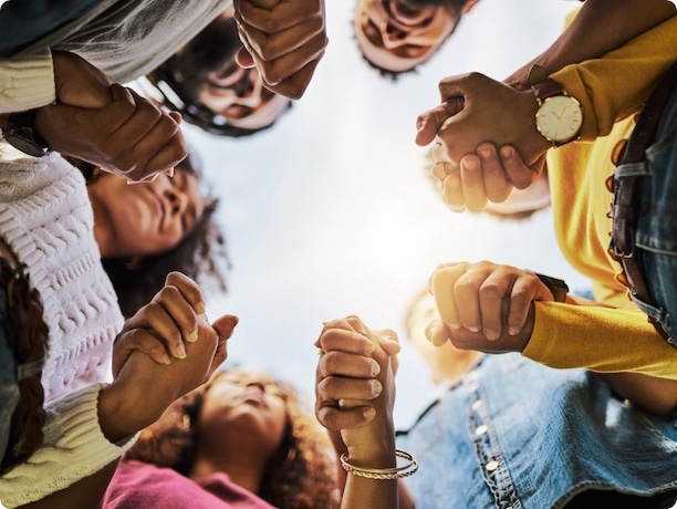 a group of people holding hands in a circle.