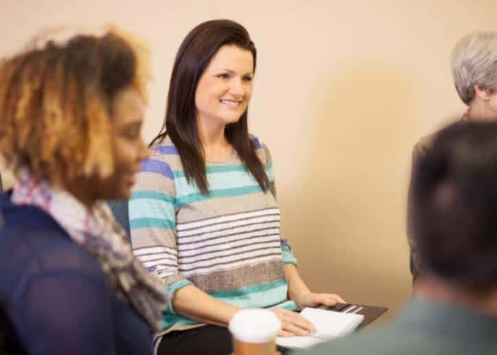 a woman standing in front of a group of people.