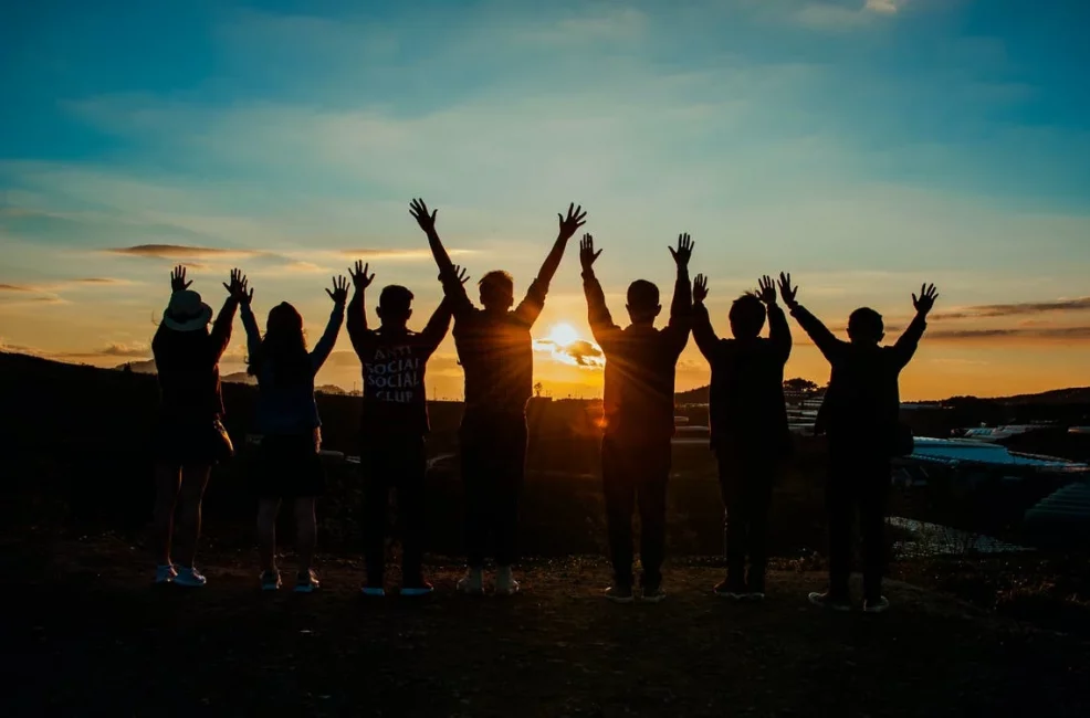 a group of people standing on top of a hill.