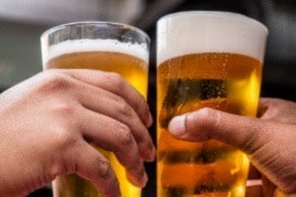 a group of people holding glasses of beer.